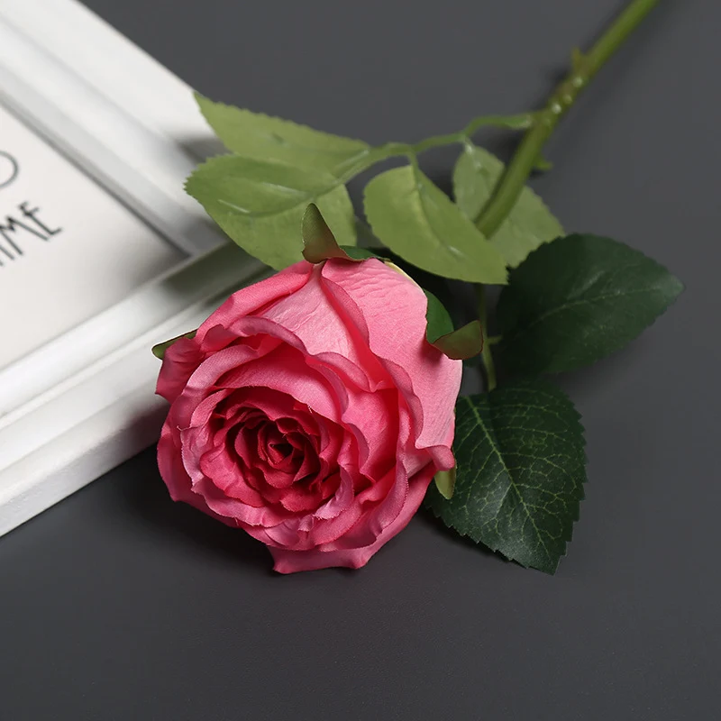 Realistische Seidenrose mit Grünanlagen