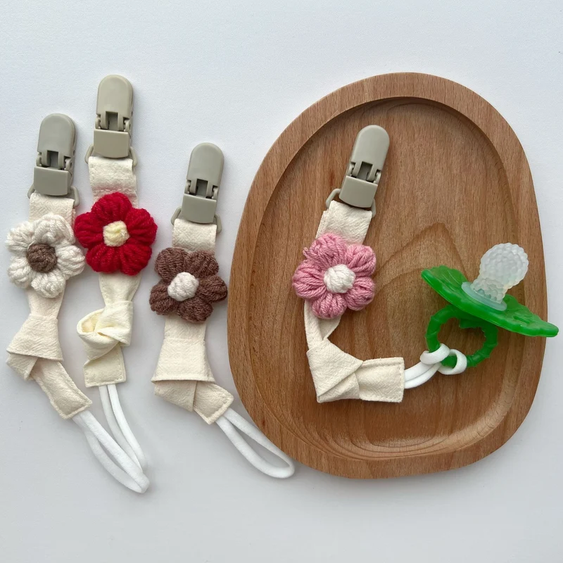 Handgemachter Baumwoll-Schnullerclip mit Gingham-Gurt und gestrickter Blume