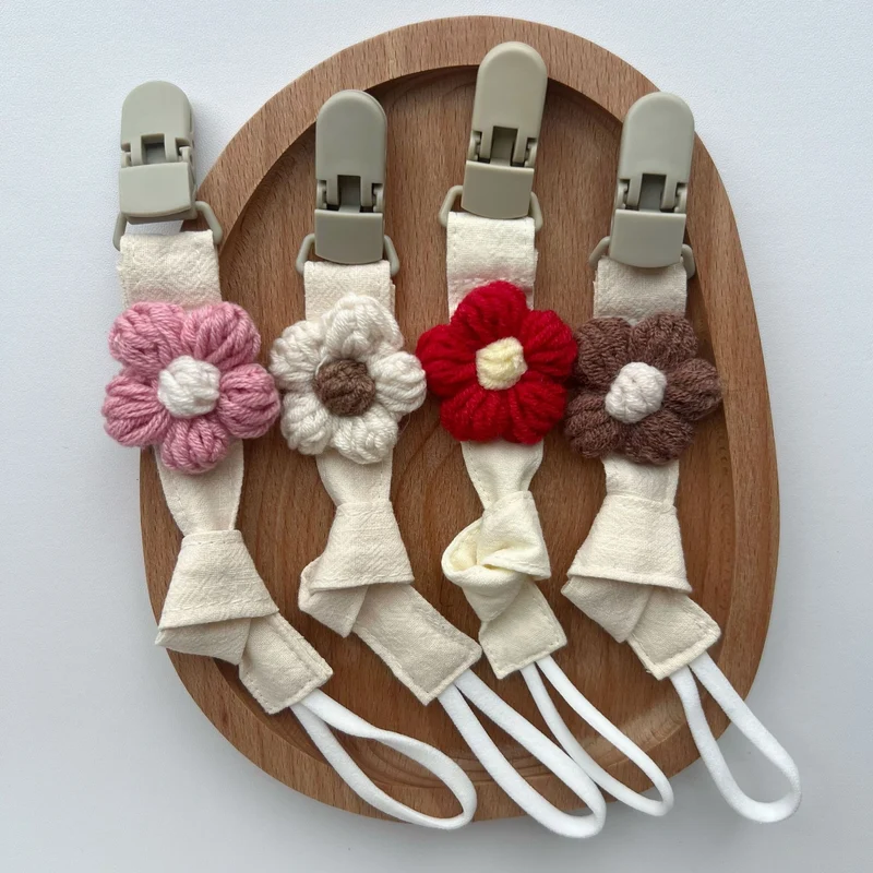 Handgemachter Baumwoll-Schnullerclip mit Gingham-Gurt und gestrickter Blume