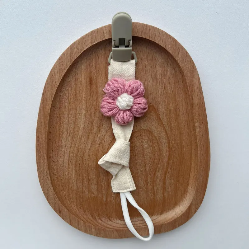 Handgemachter Baumwoll-Schnullerclip mit Gingham-Gurt und gestrickter Blume