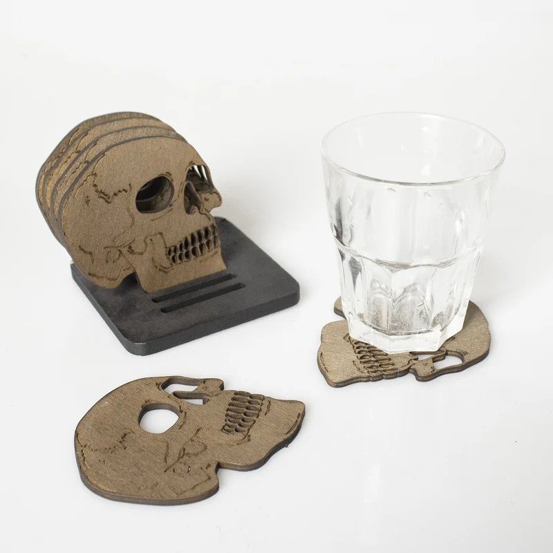 Set aus lasergravierten Holz-Untersetzern in Totenkopf-Form mit Aufbewahrungsständer