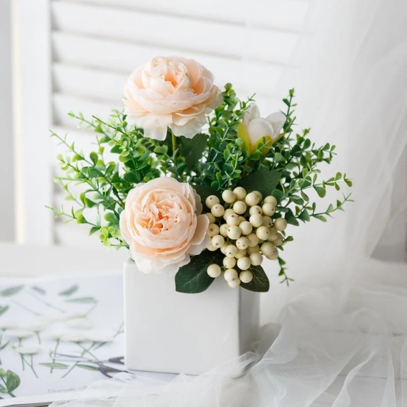 Lebensechte Blumenarrangement in dekorativem quadratischen Pflanzgefäß