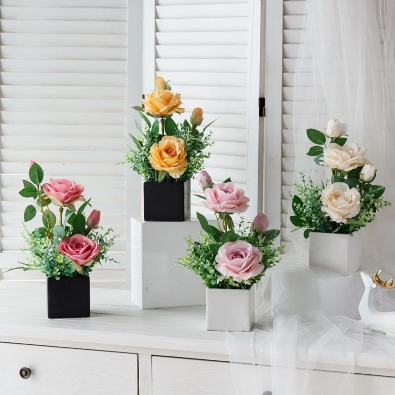 Lebensechte Blumenarrangement in dekorativem quadratischen Pflanzgefäß