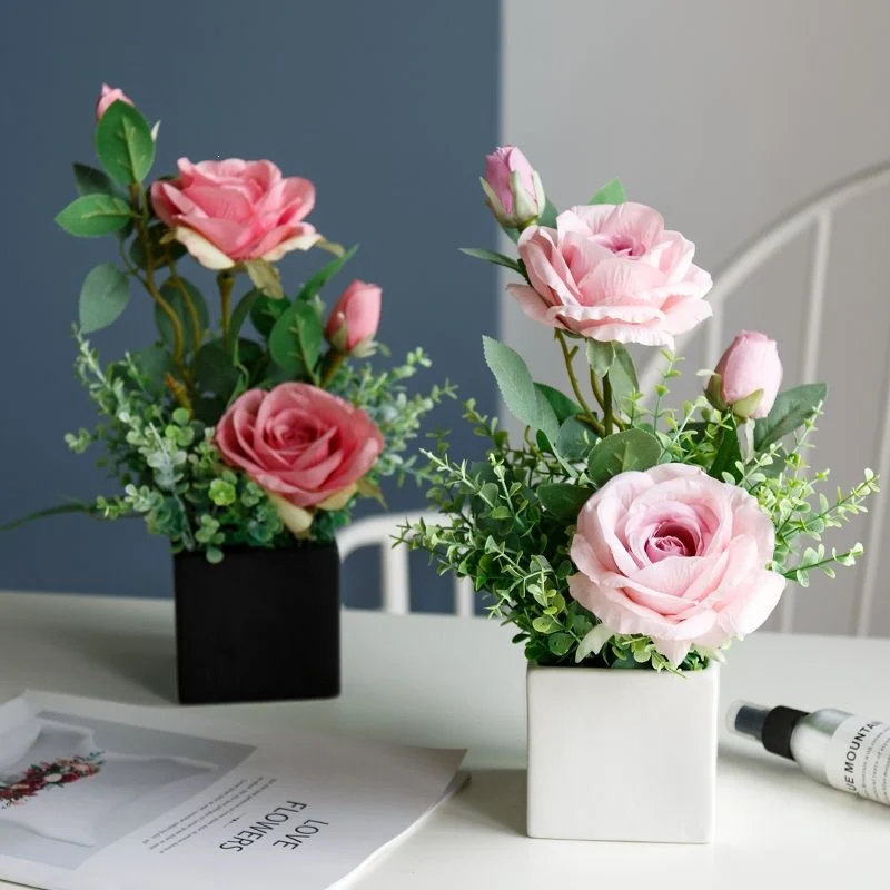 Lebensechte Blumenarrangement in dekorativem quadratischen Pflanzgefäß