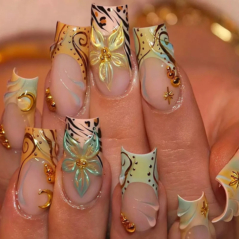 Luxuriöses Kunstnagelset mit kreativen floralem Design und goldenen Akzenten Karnz
