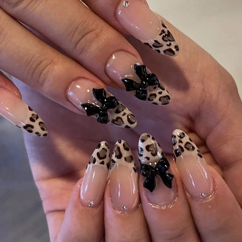 Kunstnagelset mit glamourösem Leopardenmuster und eleganten Schleifen Karnz