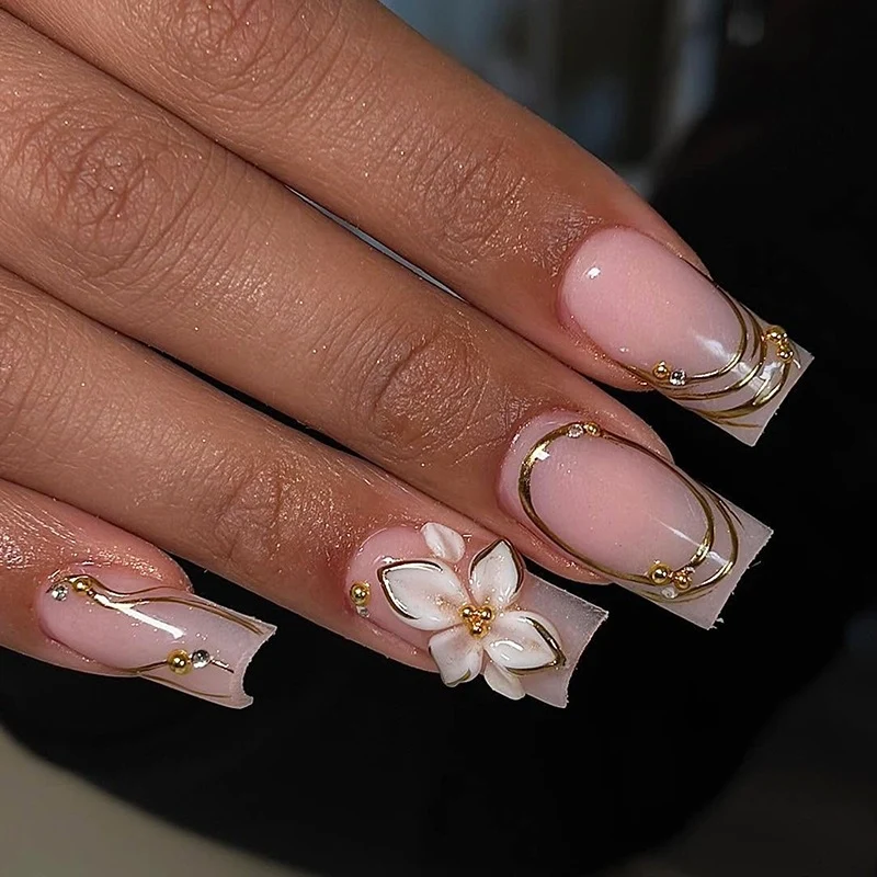 Kunstnagelset mit floralen Verzierungen und goldenen Akzenten Karnz