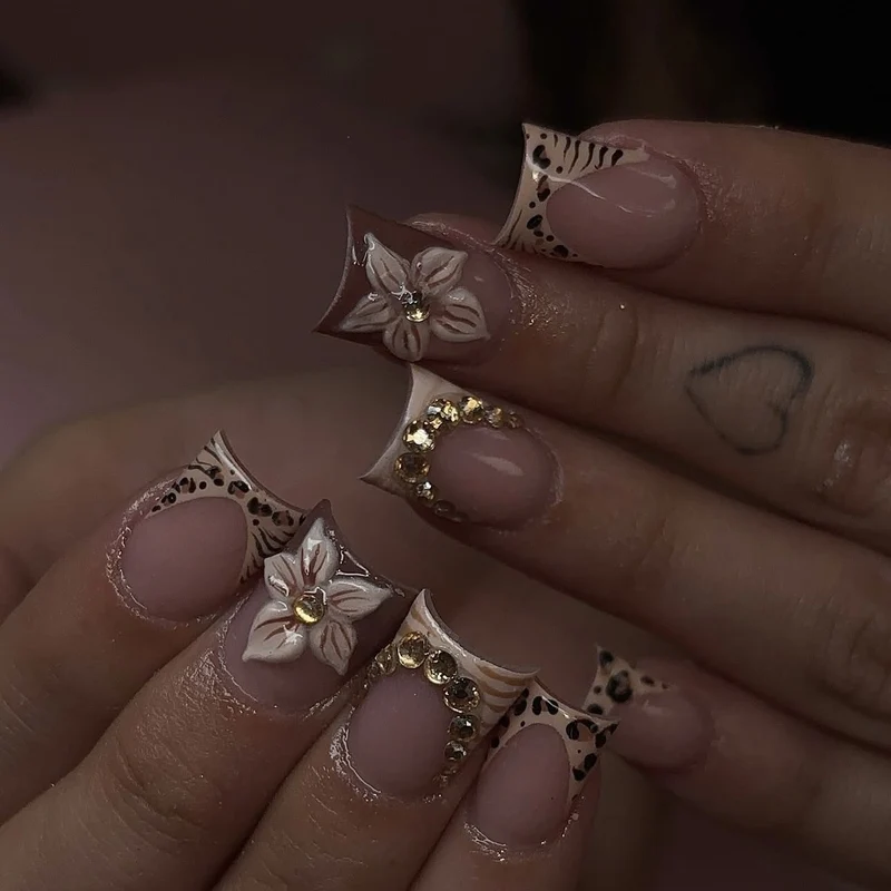 Kunstnagelset mit floralen Verzierungen und eleganten Glitzerdetails Karnz