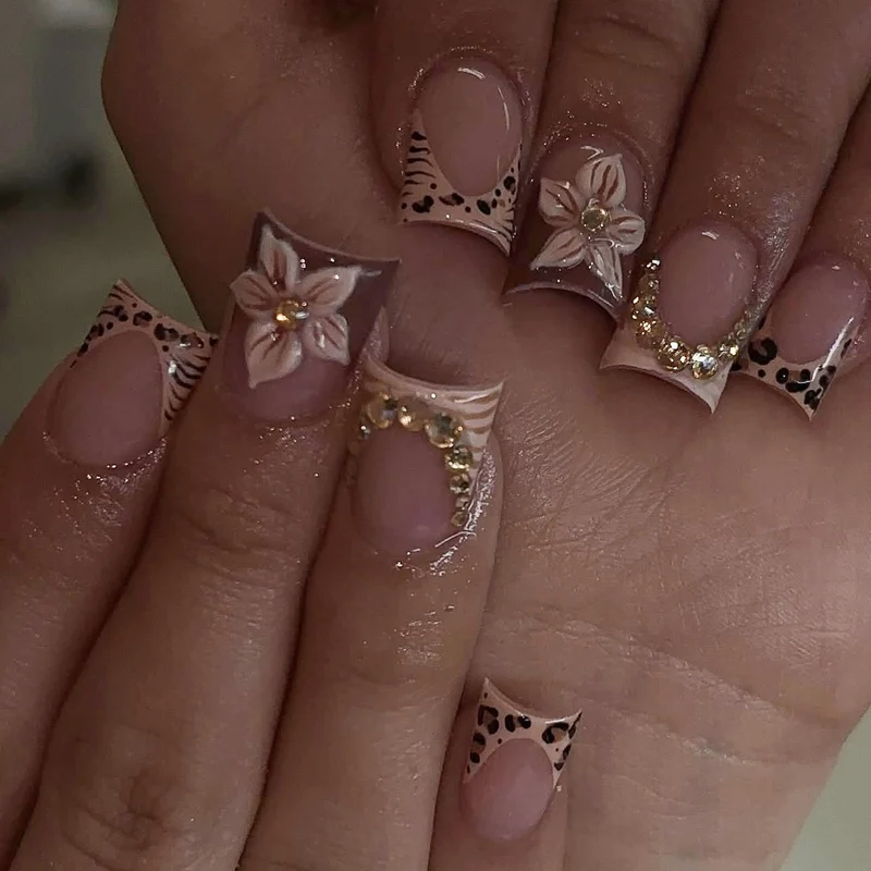 Kunstnagelset mit floralen Verzierungen und eleganten Glitzerdetails Karnz