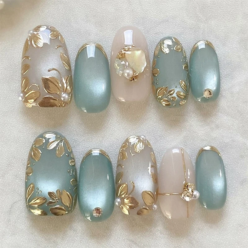 Kunstnagelset mit floralen Goldakzenten und eleganten Designs Karnz
