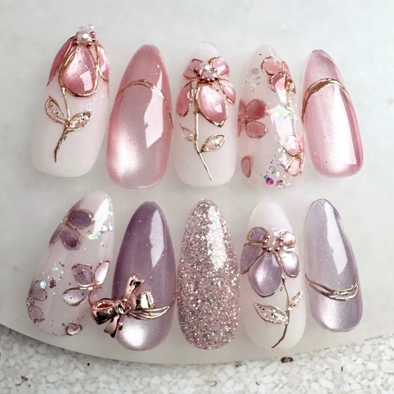 Kunstnagelset mit floralen Goldakzenten und eleganten Designs Karnz