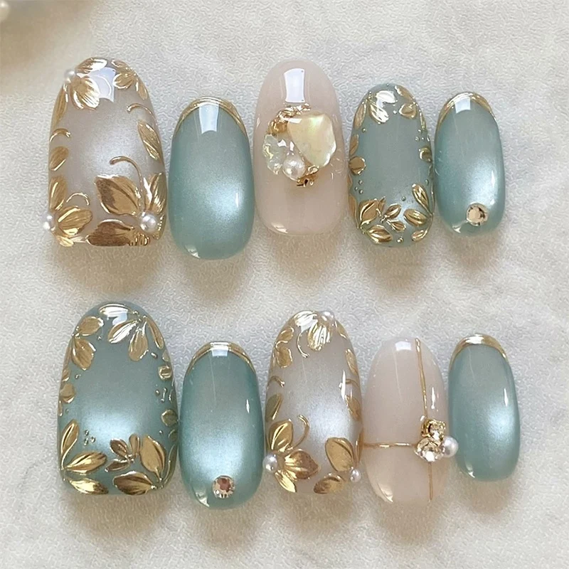 Kunstnagelset mit floralen Goldakzenten und eleganten Designs Karnz