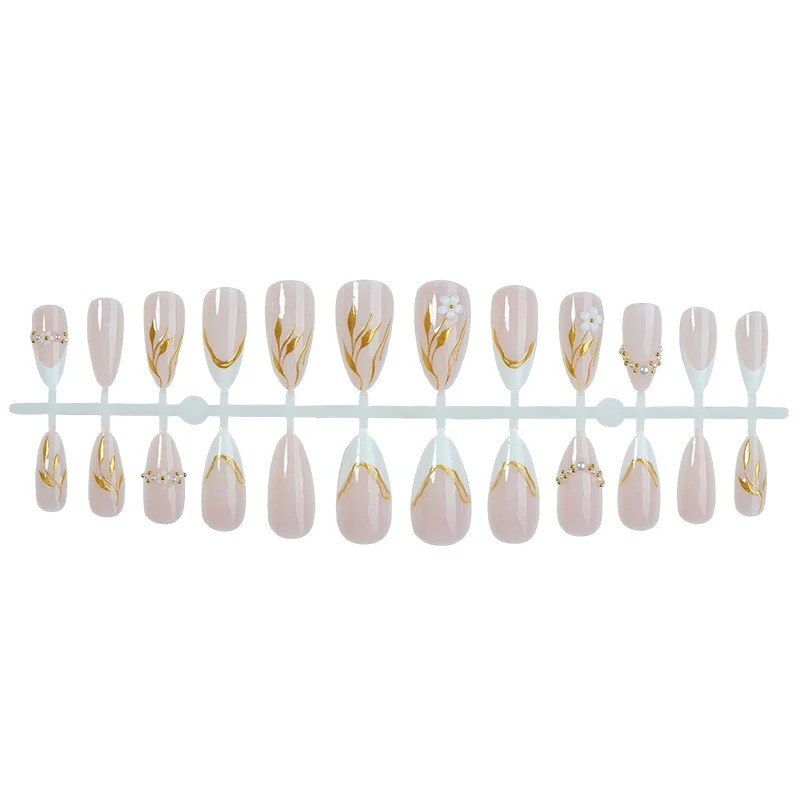 Kunstnagelset mit eleganten Goldakzenten und floralen Designs Karnz